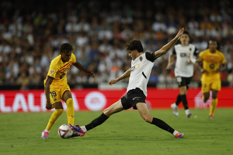 VALENCIA, 17/08/2024.- El delantero del FC Barcelona Lamine Yamal (i) lucha con Jesús Vázquez, del Valencia CF, durante el partido de LaLiga que Valencia CF y FC Barcelona disputan este sábado en el estadio de Mestalla, en Valencia. EFE/Biel Aliño