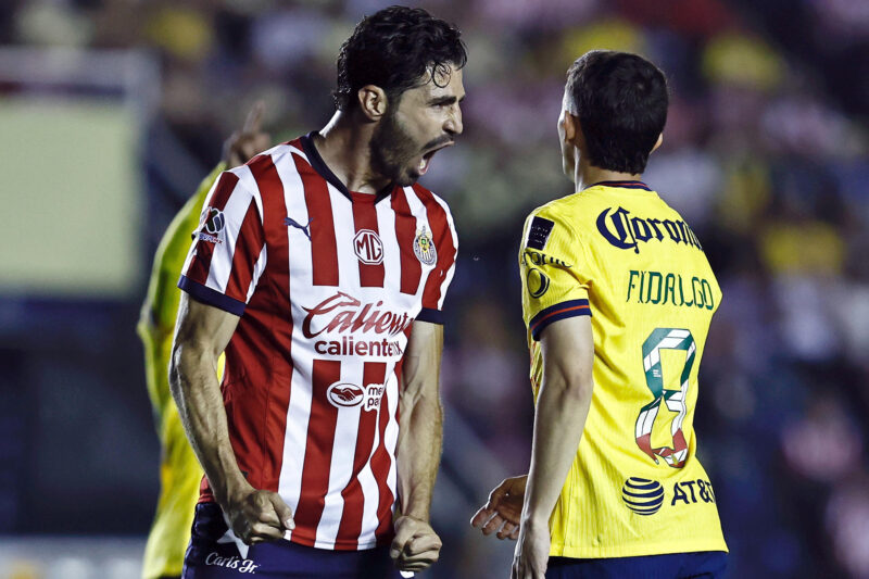 MEX8741. CIUDAD DE MÉXICO (MÉXICO), 14/09/2024.- Antonio 'Pollo' Briseño (i) de las Chivas de Guadalajara reacciona ante Álvaro Fidalgo de América este sábado, durante un partido correspondiente a la jornada 7 del torneo Apertura 2024 en el estadio Ciudad de los Deportes en Ciudad de México (México). EFE/ Sáshenka Gutiérrez