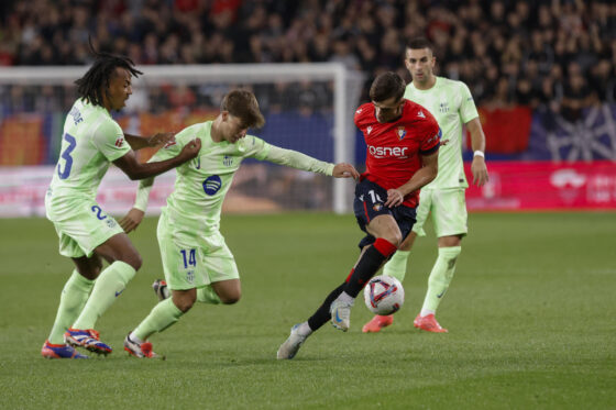El centrocampista de Osasuna Aimar Oroz (2-d) trata de escapar de Pablo Torre (2-i) y Jules Koundé (i), del FC Barcelona, durante el partido de LaLiga en Primera División en el estadio de El Sadar, en Pamplona. EFE/Villar López