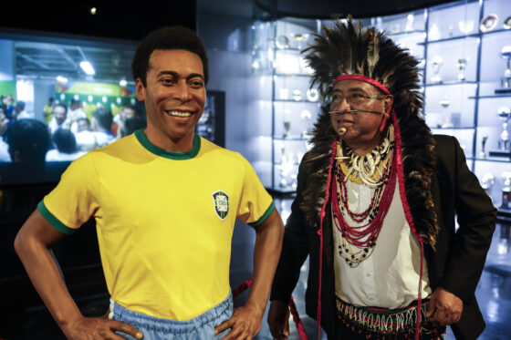 Un líder indígena posa junto a una imagen del astro brasileño 'Pelé' en el Museo del Fútbol en Río de Janeiro. EFE/ Antonio Lacerda