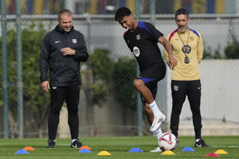 Lamine Yamal estrena diseño en sus brackets previo a 'El Clásico' El entrenador del Barcelona Hansi Flick (iz) observa a Lamine Yamal durante el entrenamiento de este viernes. EFE/Alejandro García.