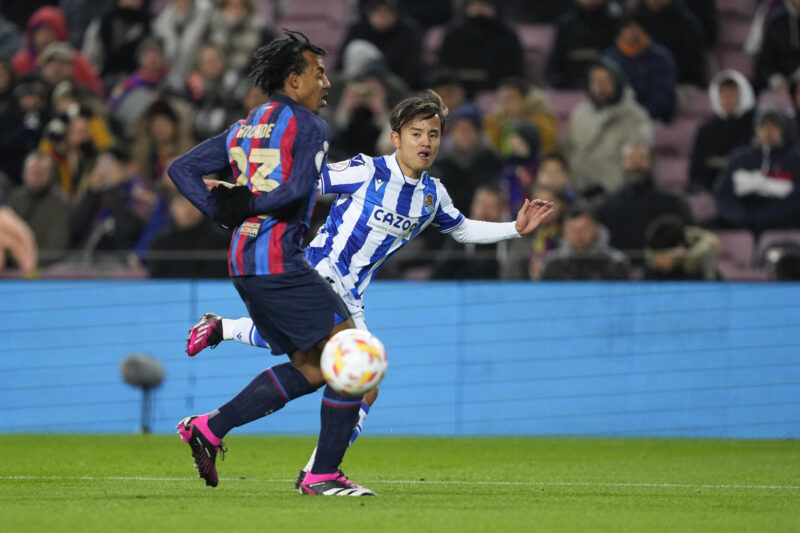 El jugador japonés de la Real Sociedad, Takefusa Kubo (d), tras golpear el balón ante el defensa francés del FC Barcelona, Jules Koundé, en una foto de archivo. EFE / Alejandro García.