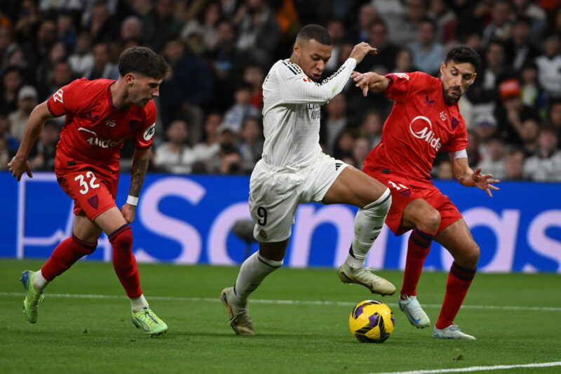 El delantero francés del Real Madrid, Kylian Mbappé (c) durante el partido de LaLiga entre el Real Madrid y el Sevilla, este domingo en el estadio Santiago Bernabéu. EFE/ Fernando Villar
