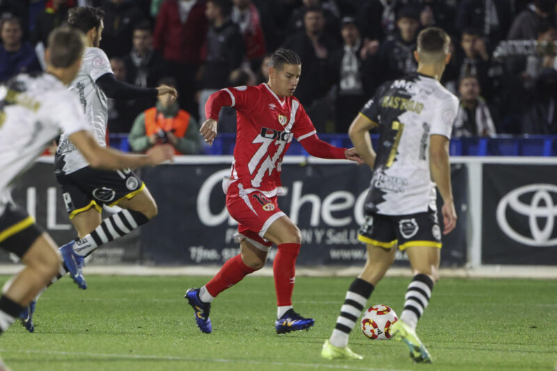 El centrocampista colombiano del Rayo Vallecano, James Rodríguez (c), conduce el balón ante los jugadores del Unionistas CF durante el encuentro correspondiente a la segunda ronda de la Copa del Rey que disputan hoy miércoles Unionistas CF y Rayo Vallecano en el estadio municipal Reina Sofía de Salamanca. EFE/JMGARCIA.