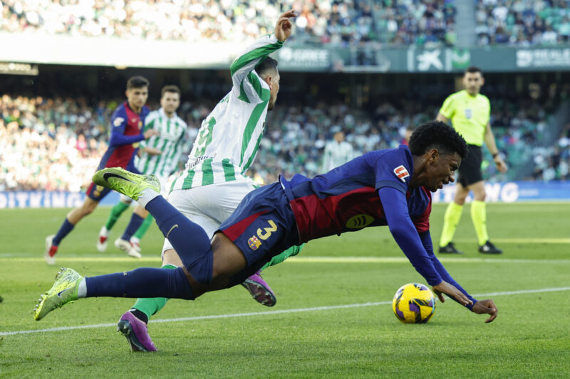 El defensa español del FC Barcelona Alejandro Balde (d) disputa un balón con el delantero argentino del Betis Chimy Ávila (i) durante el partido de la jornada décimo sexta de LaLiga EA Sports entre el Real Betis Balompié y FC Barcelona en el Estadio Benito Villamarín de Sevilla. EFE/ Julio Muñoz