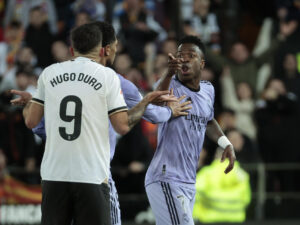 El delantero brasileño del Real Madrid Vinicius Jr. se dirige al jugador del Valencia Hugo Duro, durante el partido disputado la pasada temporada en Mestalla. EFE / Biel Aliño
