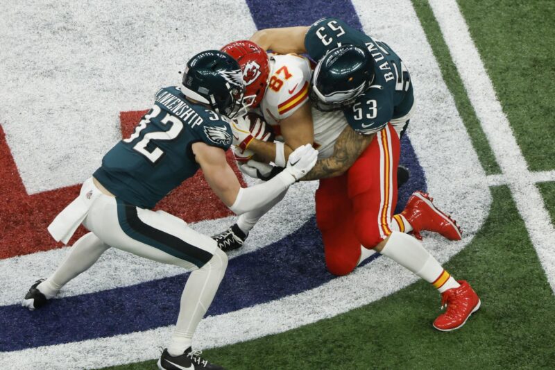 El ala cerrada de los Kansas City Chiefs, Travis Kelce (c), es bloqueado por el safety de los Philadelphia Eagles, Reed Blankenship (i), y el linebacker de los Philadelphia Eagles, Zack Baun (d), durante la segunda mitad del Super Bowl LIX entre los Kansas City Chiefs y los Philadelphia Eagles en el Caesars Superdome de Nueva Orleans, Luisiana (EE.UU.), EFE/CJ GUNTHER