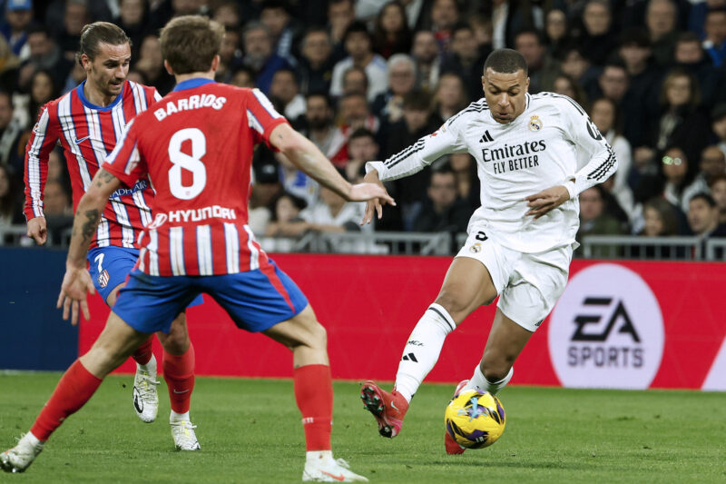 Real Madrid vs Atlético Madrid: La mejor apuesta de Champions League El delantero del Real Madrid Kylian Mbappé frente a los jugadores del Atlético Pablo Barrios (c) y Antoine Griezmann (i), en el último derbi disputado el 8 de febrero en el Santiago Bernabéu. EFE/Chema Moya