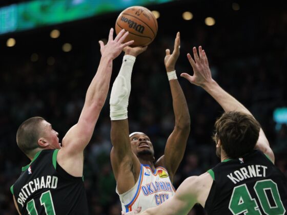 El escolta de Oklahoma City Thunder, Shai Gilgeous-Alexander (c), lanza a canasta ante la presión del escolta de Payton Pritchard (i), y el pívot Luke Kornet (d), durante el partido que ganaron a domicilio este miércoles a Boston Celtics. EFE/EPA/CJ GUNTHER