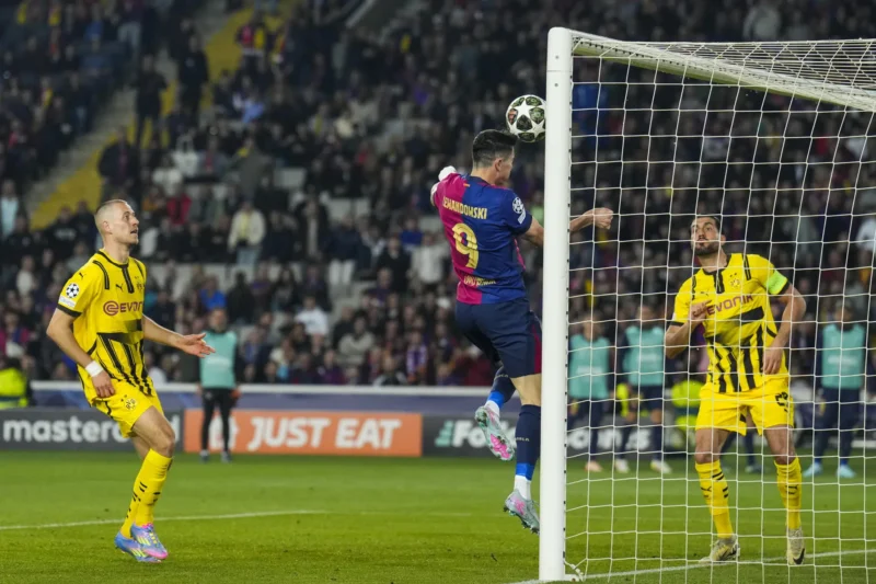 BARCELONA, 09/04/2025.- El delantero polaco del FC Barcelona, Robert Lewandowski (c), remata en la jugada que ha significado el segundo gol de su equipo durante el encuentro correspondiente a la ida de los cuartos de final de la Liga de Campeones que disputan hoy miércoles FC Barcelona y Borussia Dortmund en el Estadio Olímpico de Montjuic, en Barcelona. EFE / Alejandro García.