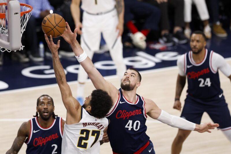 El escolta de los Denver Nuggets Jamal Murray (I), avanza hacia la canasta con la pelota mientras es defendido por el pívot de Los Angeles Clippers, Ivica Zubac (D), durante la segunda mitad del partido de playoffs de primera ronda entre los Denver Nuggets y Los Angeles Clippers en Inglewood, California, EE. UU. EFE/EPA/CAROLINE BREHMAN