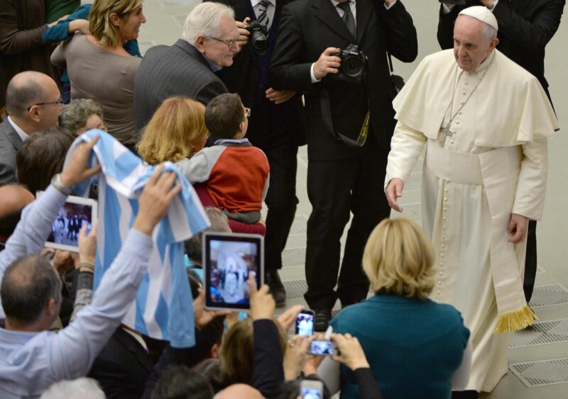 Un voluntario saluda al Papa Francisco (d) mostrando una camiseta de la selección argentina de fútbol en 2014 en foto de archivo de Maurizio Brambatti. EFE