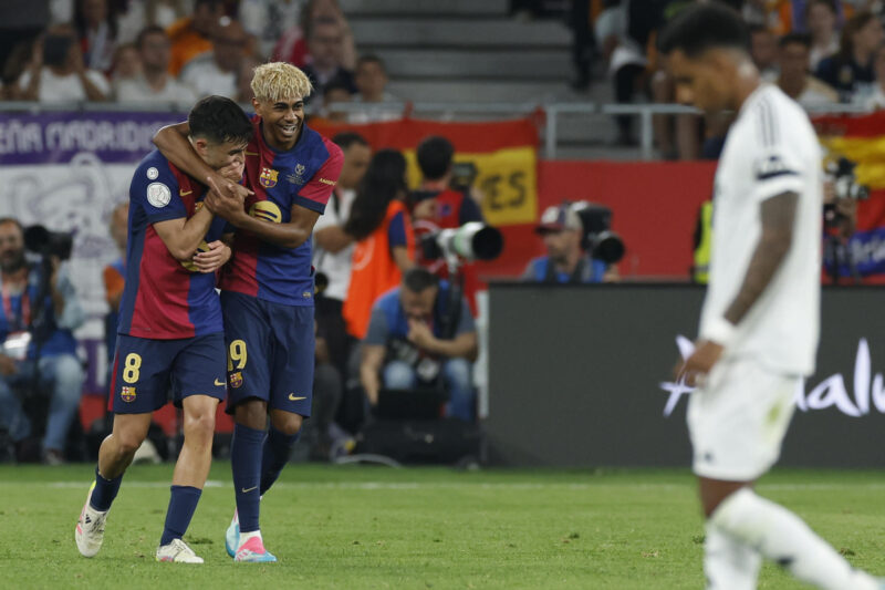 Los jugadores del FC Barcelona, Pedri (i) y Lamine Yamal, celebran el primer gol del equipo blaugrana durante el encuentro correspondiente a la final de la Copa del Rey que disputan Real Madrid y FC Barcelona en el estadio de La Cartuja, en Sevilla. EFE / Julio Muñoz.