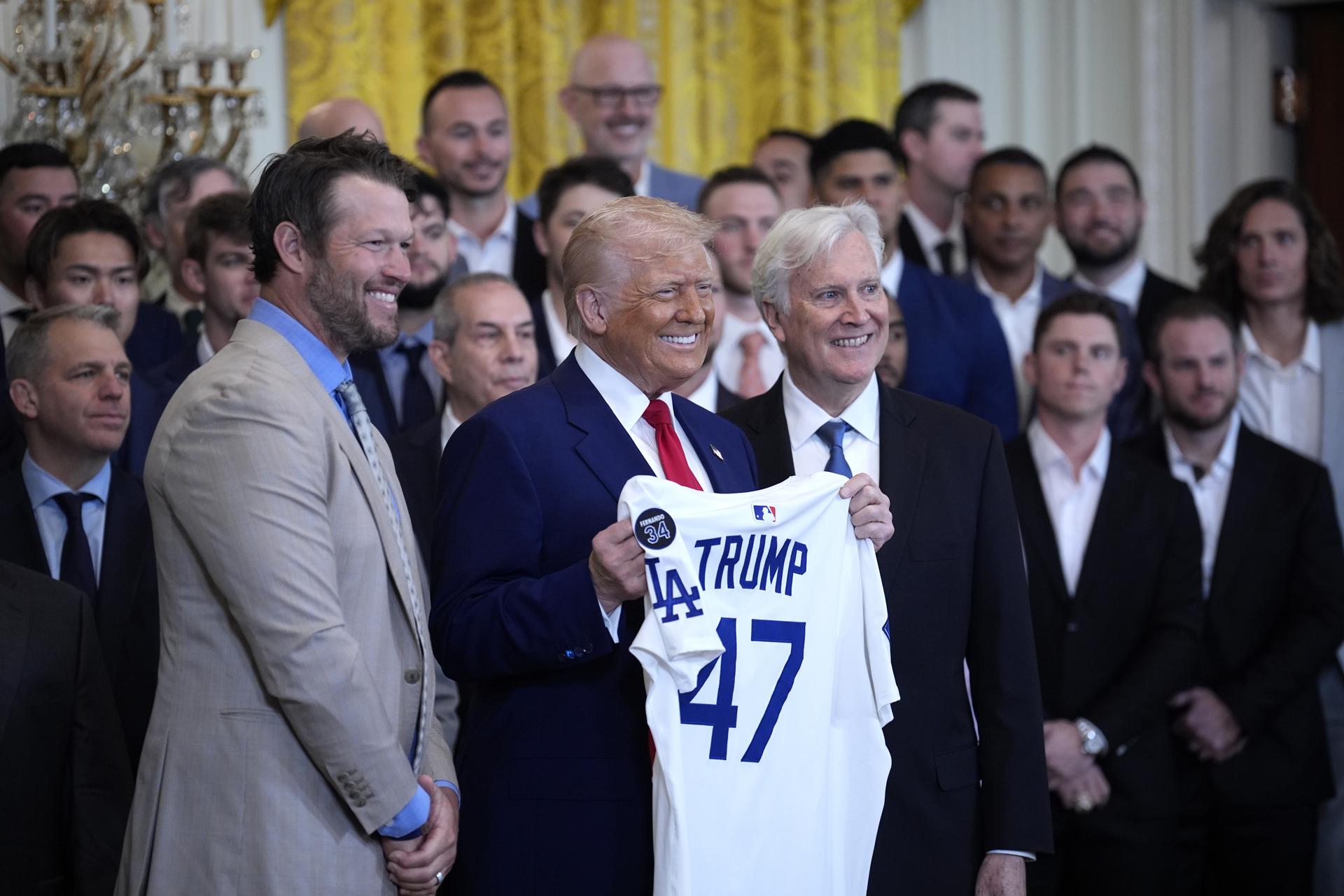 El presidente de EE.UU., Donald Trump (c), posa con una camiseta regalada por el jugador Clayton Kershaw (i) durante una reunión con los campeones de la Serie Mundial 2024 - Los Angeles Dodgers - en el Salón Este de la Casa Blanca en Washington, DC (EE.UU.). EFE/YURI GRIPAS / POOL 