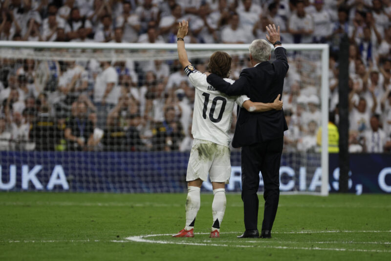El entrenador del Real Madrid, Carlo Ancelotti (d), y el centrocampista croata Luka Modrić (i) reciben un homenaje tras su último partido en el Santiago Bernabéu al término del encuentro de la jornada 38 de LaLiga EA Sports entre Real Madrid y Real Sociedad celebrado este sábado en el estadio Santiago Bernabéu de Madrid. EFE/ J.J.Guillén