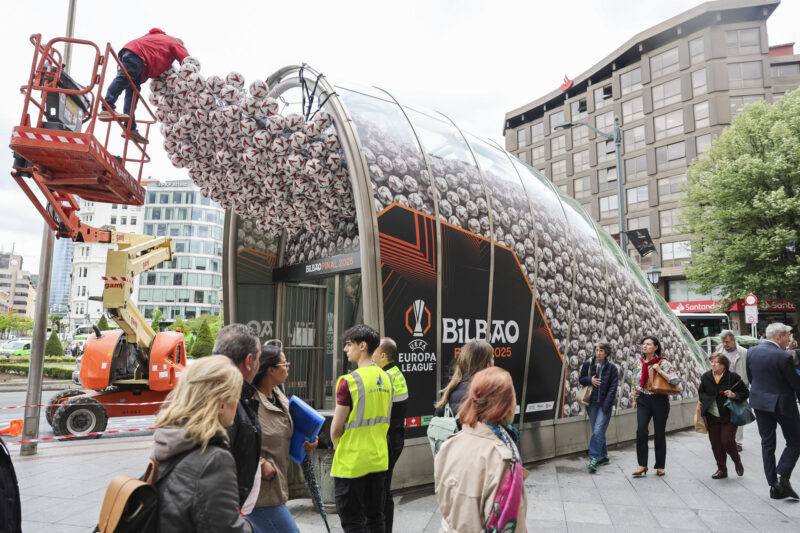 Un operario coloca balones en una boca de metro de la capital vizcaína con motivo del la final del próximo miércoles. Bilbao recibirá a miles de hinchas británicos, unos 55.000 según las estimaciones municipales, para la final de la Liga Europa que este miércoles disputarán el Tottenham Hotspur y el Manchester United, en la que el Ayuntamiento no espera incidentes importantes ante la buena relación entre las dos aficiones. EFE/Luis Tejido