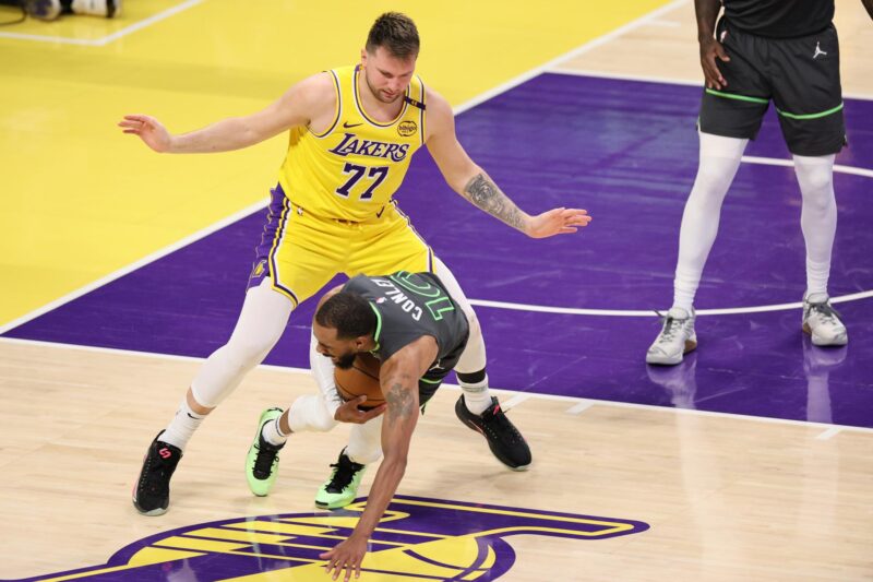 Luka Doncic (I) de Los Angeles Lakers se queda atrás mientras Mike Conley (abajo) de los Minnesota Timberwolves se cae durante la segunda mitad del quinto partido de la primera ronda de los playoffs de la NBA entre los Minnesota Timberwolves y Los Angeles Lakers en Los Ángeles, California, EE.UU. EFE/EPA/ALLISON DINNER