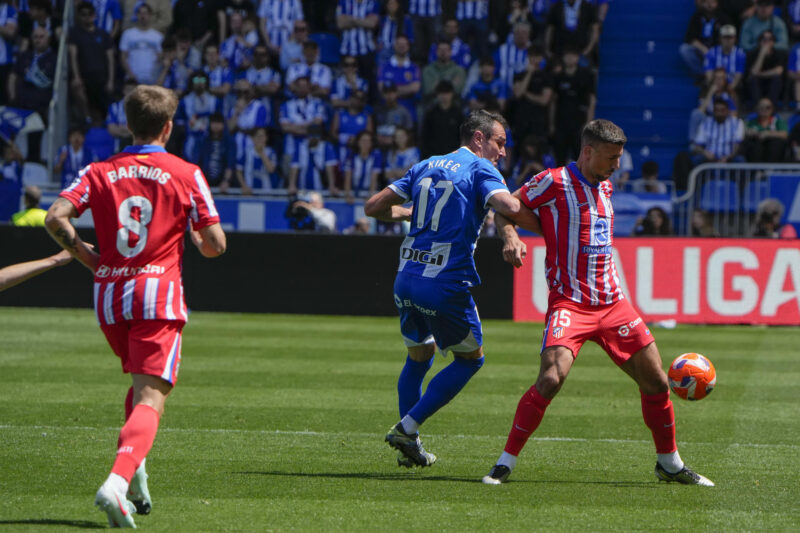Pablo Barrios (i) y Clément Laurent (d), del Atlético de Madrid, luchan por el balón con Kike García (c), del Deportivo Alavés, durante el partido de LaLiga que enfrentó a sus equipos en el estadio de Mendízorrotza en Vitoria-Gasteiz.  EFE/Adrián Ruiz Hierro