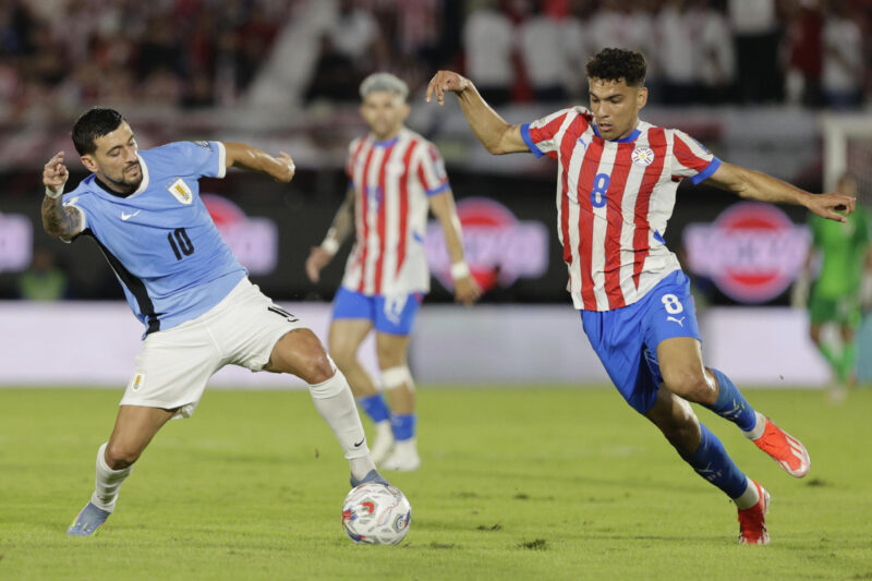 AMDEP6806. ASUNCIÓN (PARAGUAY), 05/06/2025.- Diego Gómez (d) de Paraguay disputa un balón con Giorgian de Arrascaeta de Uruguay este jueves, durante un partido de las eliminatorias sudamericanas para el Mundial de 2026 entre las selecciones Paraguay y Uruguay en el estadio Defensores del Chaco en Asunción (Paraguay). EFE/ Juan Pablo Pino