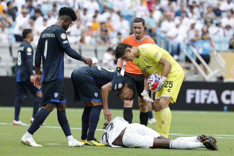 El central argentino Gustavo Cabral, capitán de Pachuca (2-i), se inclina sobre el defensor alemán del Real Madrid, Antonio Rüdiger, quien aparece tendido en el césped del Bank Of America Stadium durante el partido de la segunda jornada del Grupo H del Mundial de Clubes, que el equipo blanco ganó por 3-1 al mexicano en la ciudad estadounidense de Charlotte. EFE/EPA/ERIK S. LESSER