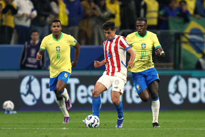Vinicius (d), de Brasil, disputa el balón con Andrés Cubas (c), de Paraguay, en un partido por las eliminatorias sudamericanas para el Mundial 2026 entre las selecciones de Brasil y Paraguay en el estadio Neo Química Arena en Sao Paulo (Brasil). EFE/ Isaac Fontana