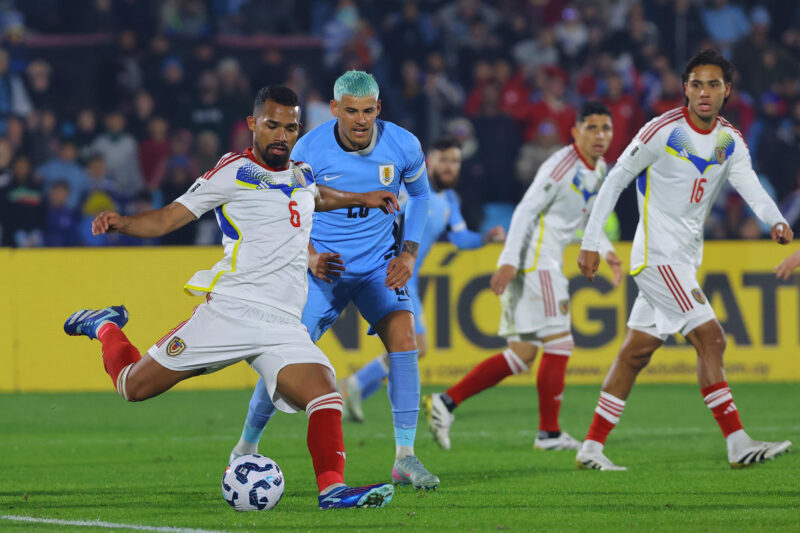 El extremo uruguayo Maximiliano Araújo (c) marca elavance del centrocampista venezolano Yangel Herrera (i) durante el partido de las eliminatorias del Mundial de 2026 que la Celeste ganó este martes por 2-0 a la Vinotinto en el estadio Centenario en Montevideo. EFE/ Gastón Britos