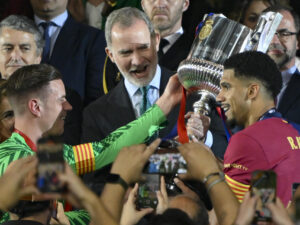 El alemán Marc André ter Stegen (i) y su compañero, el uruguayo Ronald Araujo (d), capitanes del Barcelona, recogen el trofeo de la última Copa del Rey conquistada ante el Real Madrid en el estadio de La Cartuja, en Sevilla. EFE / Raúl Caro.