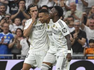 El delantero francés del Real Madrid Kylian Mbappé (c) celebra con Álvaro Carreras (izda) y Vinicius el segundo gol conseguido durante el partido de la jornada 5 de LaLiga EA Sports, que disputan el Real Madrid y el RCD Espanyol, en el estadio Santiago Bernabéu de la capital española. EFE/Fernando Villar
