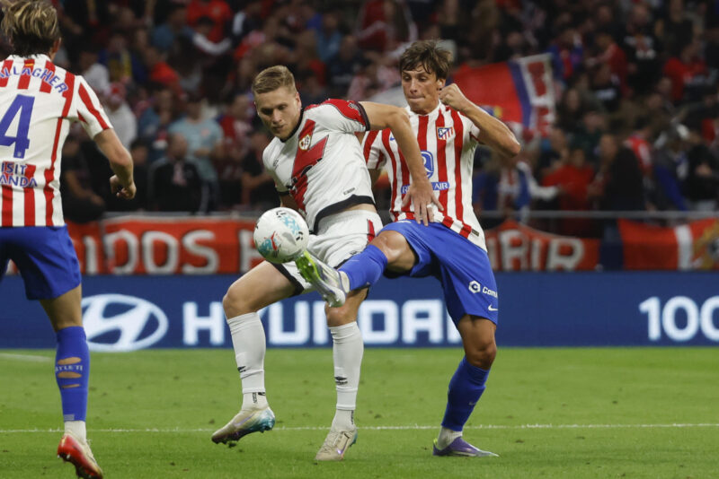 El defensa del Atlético de Madrid Le Normand (d) disputa el balón ante el defensa rumano del Rayo Vallecano Andrei Ratiu durante el partido de la jornada 6 de Liga que disputan en el estadio Riyadh Air Metropolitano, en Madrid. EFE/Juanjo Martín