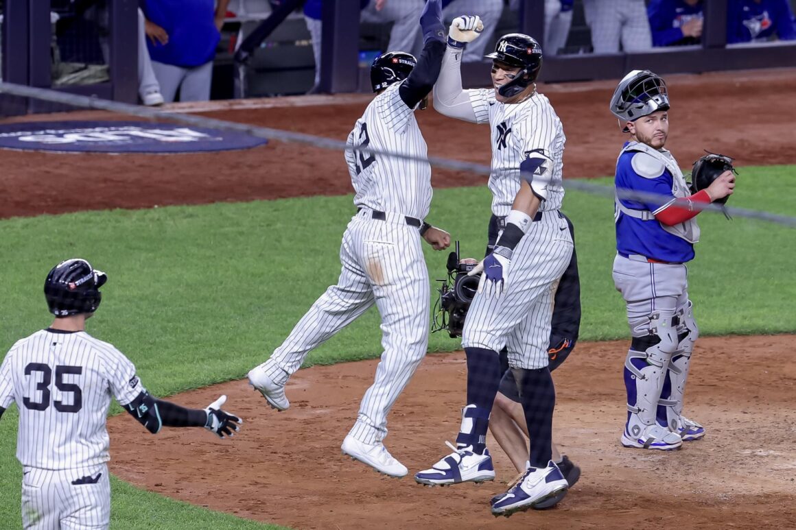 El jardinero derecho de los New York Yankees, Aaron Judge (C), celebra con el jardinero central, Trent Grisham (I), después de conectar un jonrón de tres carreras, mientras el receptor de los Toronto Blue Jays, Alejandro Kirk (D), observa en la cuarta entrada del juego 3 de la serie de playoffs de la División Americana de la MLB. EFE/EPA/SARAH YENESEL
