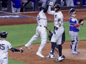 El jardinero derecho de los New York Yankees, Aaron Judge (C), celebra con el jardinero central, Trent Grisham (I), después de conectar un jonrón de tres carreras, mientras el receptor de los Toronto Blue Jays, Alejandro Kirk (D), observa en la cuarta entrada del juego 3 de la serie de playoffs de la División Americana de la MLB. EFE/EPA/SARAH YENESEL