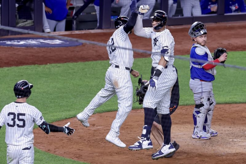 El jardinero derecho de los New York Yankees, Aaron Judge (C), celebra con el jardinero central, Trent Grisham (I), después de conectar un jonrón de tres carreras, mientras el receptor de los Toronto Blue Jays, Alejandro Kirk (D), observa en la cuarta entrada del juego 3 de la serie de playoffs de la División Americana de la MLB. EFE/EPA/SARAH YENESEL