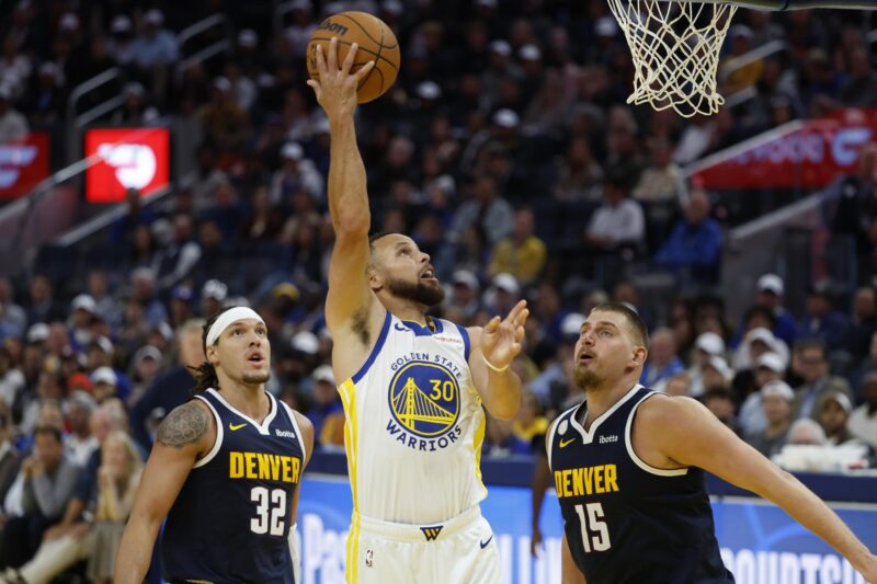 Steph Curry rescata a los Warriors ante los 50 puntos de Aaron Gordon El base de los Golden State Warriors Stephen Curry (C) en acción contra el centro de los Denver Nuggets Nikola Jokic (D) y el ala-pívot de los Denver Nuggets Aaron Gordon (I) durante la segunda mitad del partido de apertura de la temporada de los Golden State Warriors contra los Denver Nuggets en San Francisco, California, EE.UU. EFE/EPA/JOHN G. MABANGLO