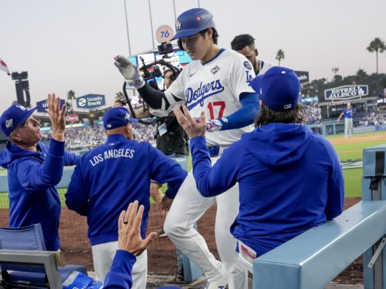 El bateador designado de los Los Angeles Dodgers, Shohei Ohtani (c), es recibido en el dugout después de conectar un jonrón en solitario contra los Azulejos de Toronto durante la tercera entrada del tercer juego de la Serie Mundial de la MLB. EFE/EPA/ALLISON DINNER