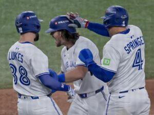 Toronto toma ventaja e histórico home run del mexicano Alejandro Kirk Addison Barger (c) es felicitado por sus compañeros de los Azulejos Nathan Lukes (i) y George Springer tras batear grand slam ante los Dodgers en el primer juego de la Serie Mundial de Béisbol en Toronto. EFE/EPA/EDUARDO LIMA