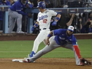 Alex Call (i), de Los Angeles Dodgers, entra a una base en pugna con Vladimir Guerrero Jr. (d) de los Azulejos de Toronto durante la 15ª entrada del juego tres de la Serie Mundial de MLB. EFE/EPA/CAROLINE BREHMAN