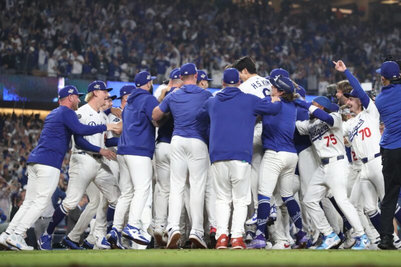 Freddie Freeman (c) de los Los Angeles Dodgers es rodeado por sus compañeros después de conectar un jonrón solitario ganador del tercer juego ante los Azulejos de Toronto Blue en la Serie Mundial de la MLB. EFE/EPA/CAROLINE BREHMAN