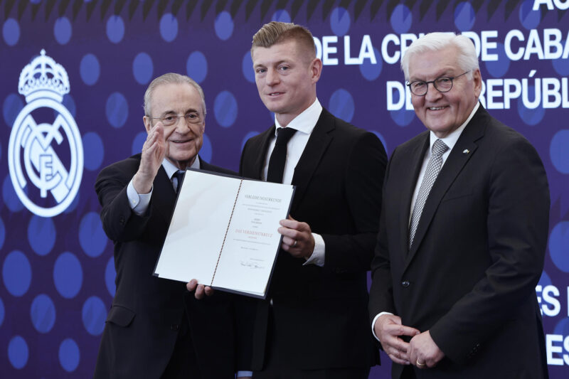 El exfutbolista Toni Kroos (c) recibe la Cruz de Caballero de la Orden del Mérito de la República Federal de Alemania de manos del presidente de Alemania, Frank-Walter Steinmeier (d), junto al presidente del Real Madrid, Florentino Pérez (i), este jueves en el Palco de Honor del Bernabéu, en Madrid. EFE/ Sergio Pérez