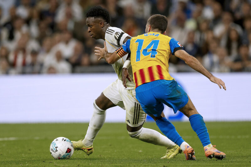 El delantero del Real Madrid Vinicius Jr. (i) se escapa de José Gayá, del Valencia, durante el partido de la jornada 11 de LaLiga que Real Madrid y Valencia CF disputaron en el estadio Santiago Bernabéu. EFE/Javier Lizón