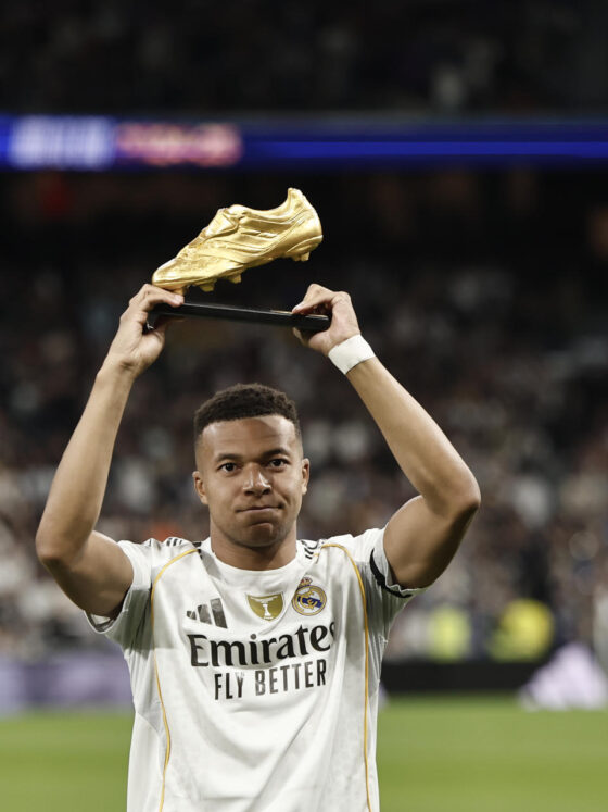 El delantero francés del Real Madrid Kylian Mbappé sostiene el trofeo de la Bota de Oro en los momentos previos al partido de LaLiga entre el Real Madrid y el Valencia, este sábado en el estadio Santiago Bernabéu. EFE/ Sergio Pérez