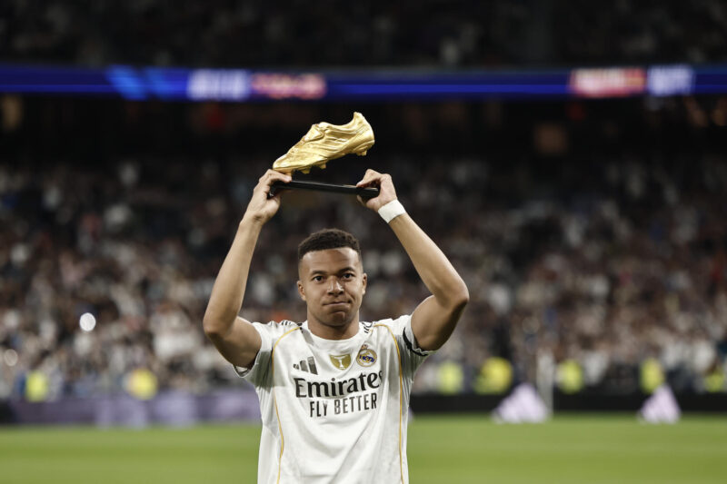 El delantero francés del Real Madrid Kylian Mbappé sostiene el trofeo de la Bota de Oro en los momentos previos al partido de LaLiga entre el Real Madrid y el Valencia, este sábado en el estadio Santiago Bernabéu. EFE/ Sergio Pérez