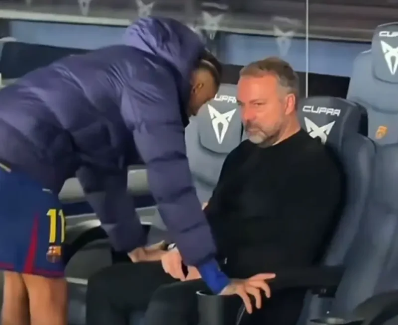 El brasileño Raphinha y el alemán Hansi Flick dialogando tras la victoria del Barcelona ante el Alavés.