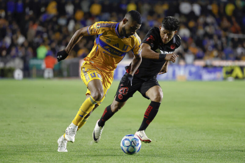 El extremo de Tigres Joaquim Pereira (i) avanza con el balón ante la marca del defensor de Toluca Jesús Gallardo (d) en partido de la tercera jornada del torneo Clausura mexicano jugado en el estadio Universitario de San Nicolás. EFE/ Antonio Ojeda