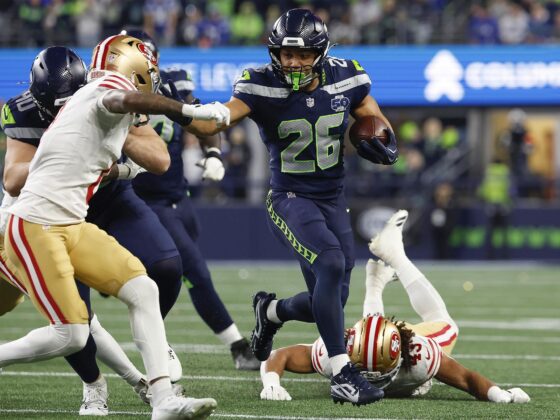 El corredor de los Seattle Seahawks, Zach Charbonnet (c), elude la marca de rivales de San Francisco 49ers durante el juego de la ronda divisiona, el 17 de enero pasado, poco antes de sufrir una delicada lesión que le hará perder el juego por el título de la Conferencia Nacional (NFC). EFE/EPA/JOHN G. MABANGLO