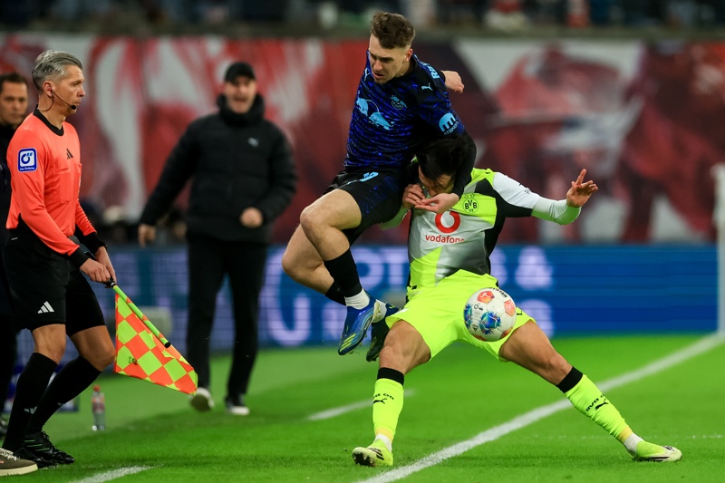LEIPZIG (Germany), 21/02/2026.- Brajan Gruda of Leipzig (L) in action against Rami Bensebaini of Borussia (R) during the German Bundesliga soccer match between RB Leipzig and Borussia Dortmund in Leipzig, Germany, 21 February 2026. (Alemania) EFE/EPA/MARTIN DIVISEK CONDITIONS - ATTENTION: The DFL regulations prohibit any use of photographs as image sequences and/or quasi-video.