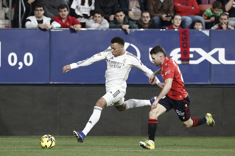 PAMPLONA, 21/02/2026.- El delantero francés del Real Madrid Kylian Mbappé (i) se escapa de Javi Galán, de Osasuna, durante el partido de la jornada 25 de LaLiga que disputan CA Osasuna y Real Madrid, este sábado en el estadio de El Sadar de Pamplona. EFE/Jesús Diges