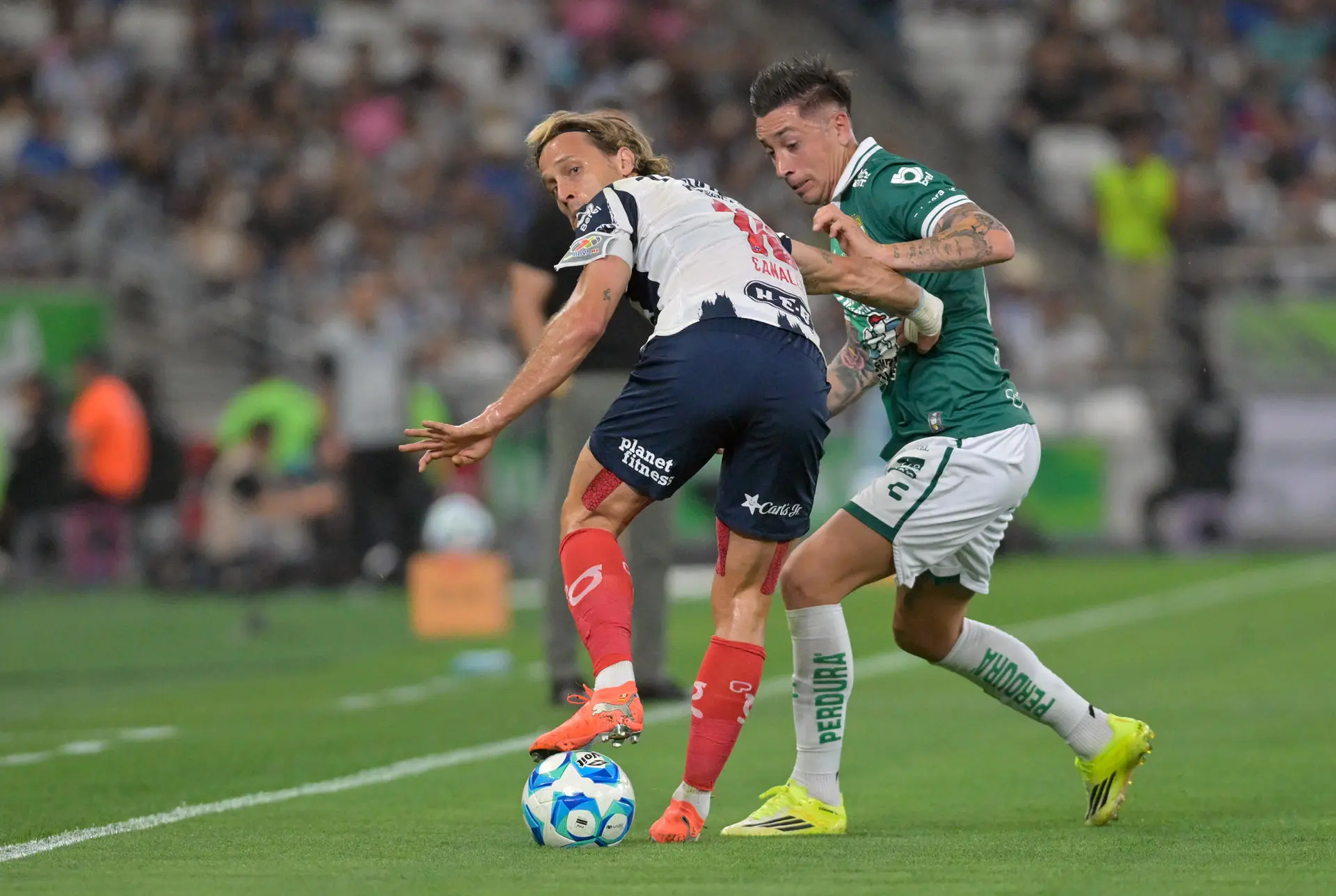 GUADALUPE (MÉXICO), 14/02/2026.- Sergio Canales (i) de Monterrey disputa el balón con Rodrigo Echeverria de León este sábado, en un partido entre Monterrey y León en el estadio BBVA en Guadalupe (México). EFE/Miguel Sierra