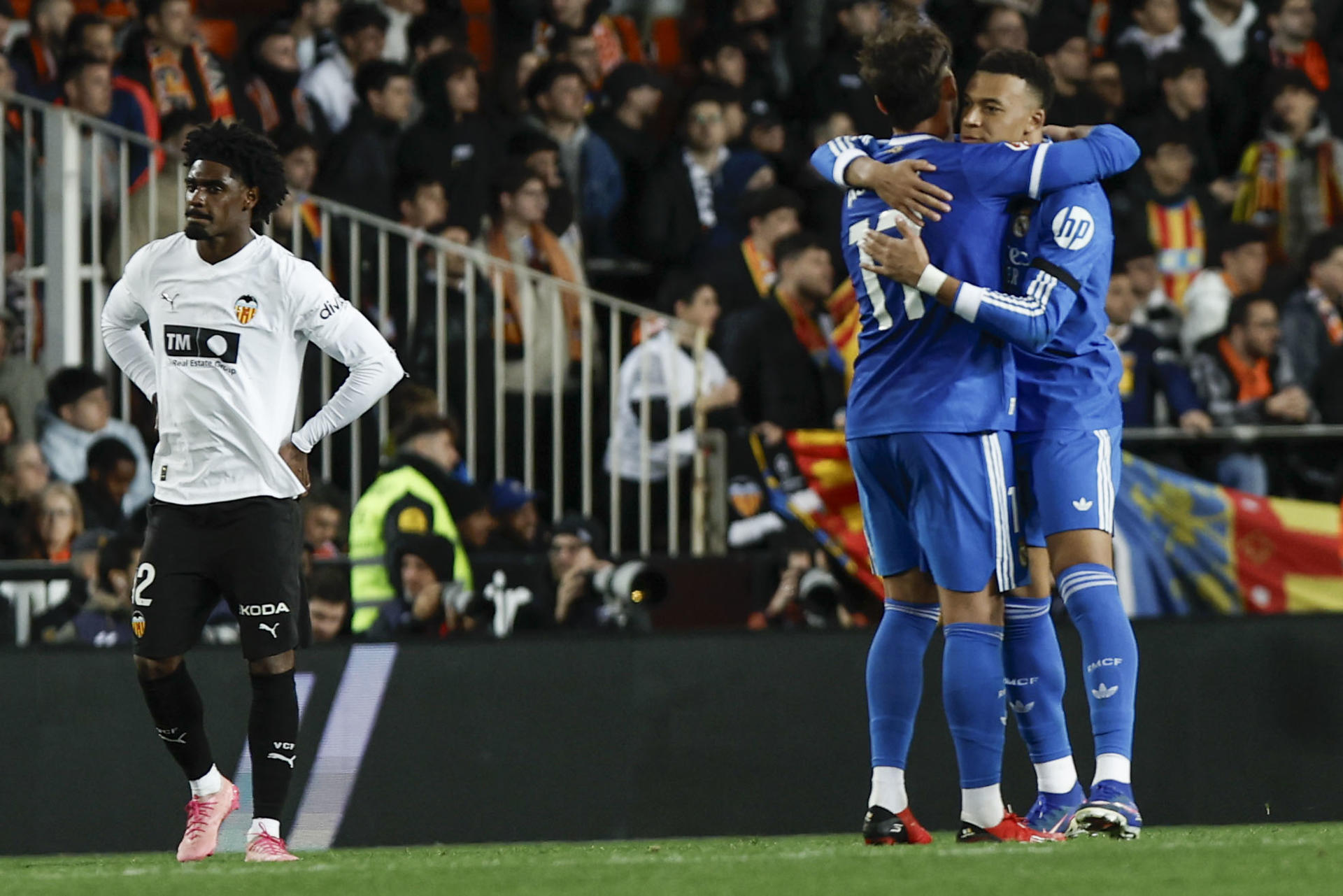 El delantero del Real Madrid Kylian Mbappé (d) celebra con Raúl Asencio (c) tras marcar el segundo gol, durante el partido de LaLiga de fútbol que Valencia CF y Real Madrid disputaron en el estadio de Mestalla. EFE/Biel Aliño