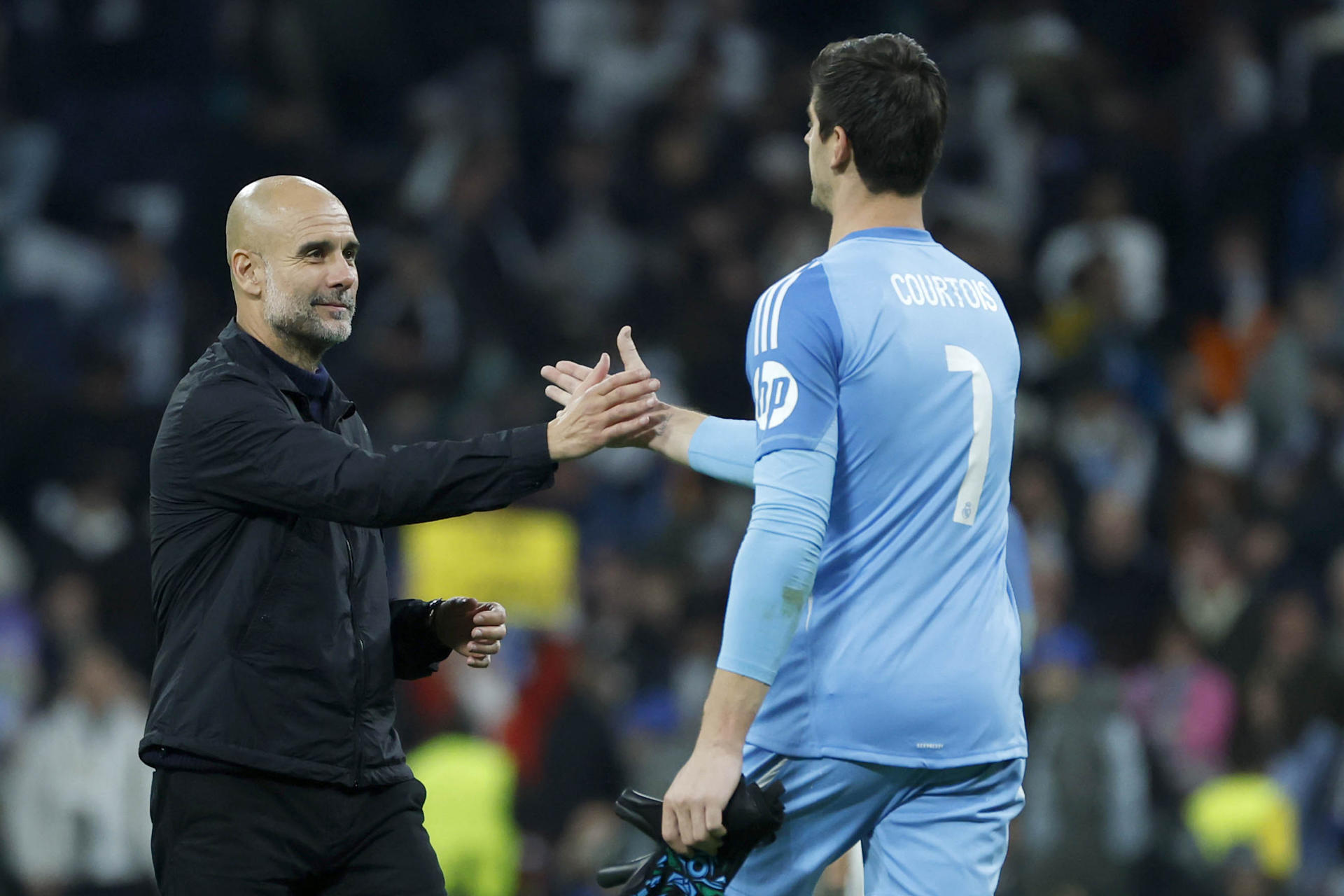 El técnico español del Manchester City, Pep Guardiola (i) y el guardameta belga del Real Madrid, Thibaut Courtois, a la finalización del encuentro correspondiente a la fase regular de la Liga de Campeones disputado el pasado 10 de diciembre. EFE/Juanjo Martín.