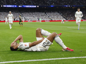 El centrocampista del Real Madrid Jude Bellingham reacciona ante el dolor tras resultar lesionado a los nueve minutos del partido de LaLiga que enfrentó al Real Madrid y al Rayo Vallecano, este domingo, en el Santiago Bernabéu. EFE/ J.J. Guillen
